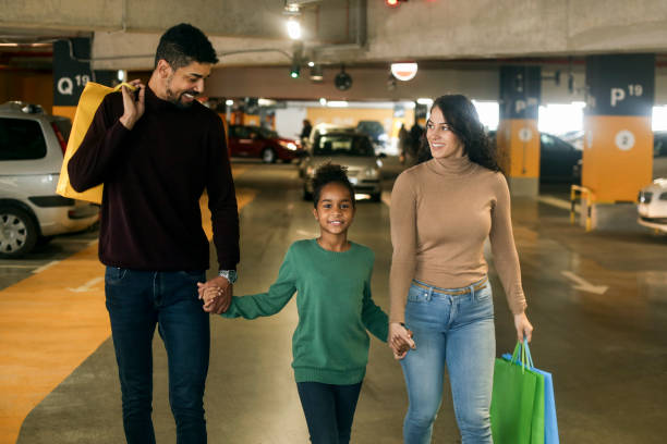 Family in parking garage with many electric ev vehicles.